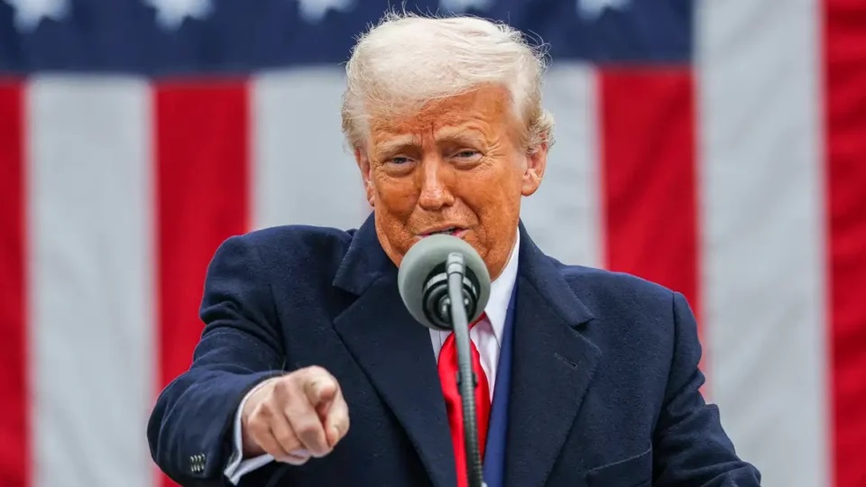 O presidente americano Donald Trump falando em microfone e apontando pra frente