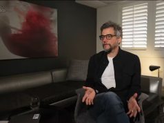 Wagner Moura sentado, falando e gesticulando