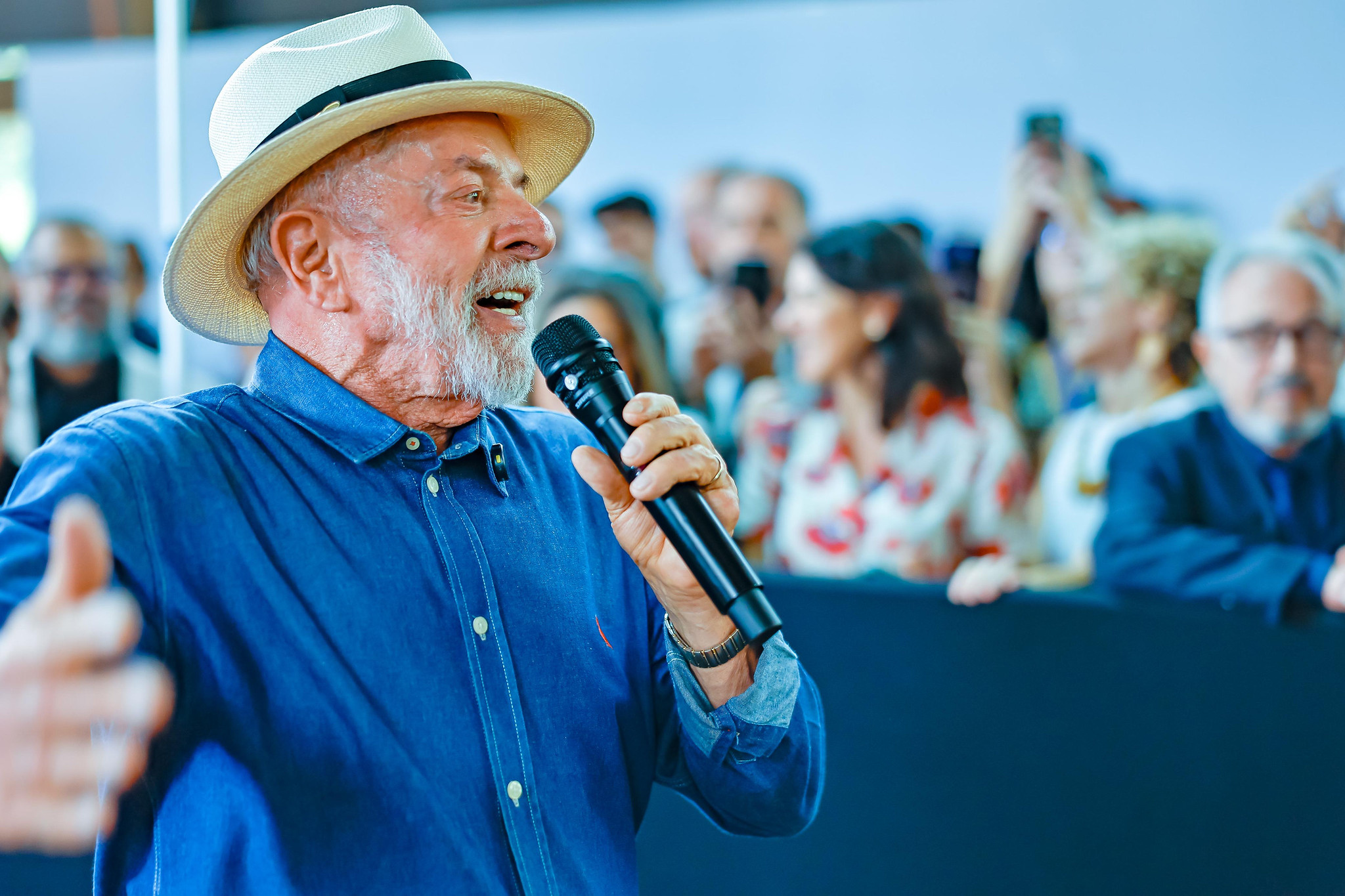 presidente Lula de camisa jeans e chapéu, falando em microfone