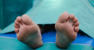 Pés de homem coberto no necrotério