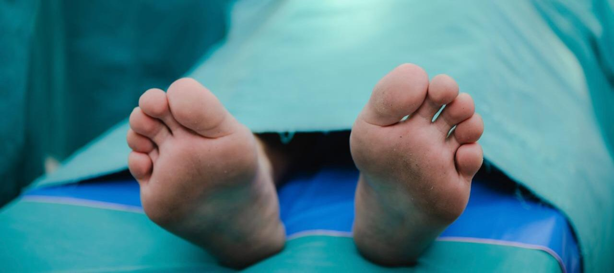 Pés de homem coberto no necrotério