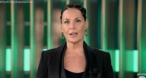 Carolina Ferraz de roupa social preta e cabelo preso, falando para a câmera