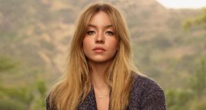 Sydney Sweeney de cabelo solto, olhando séria para a câmera