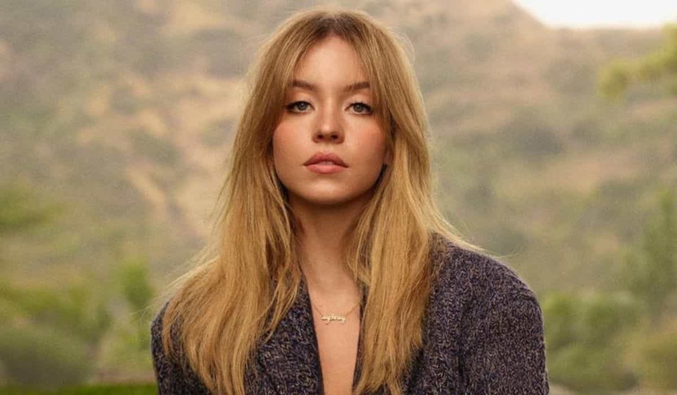 Sydney Sweeney de cabelo solto, olhando séria para a câmera