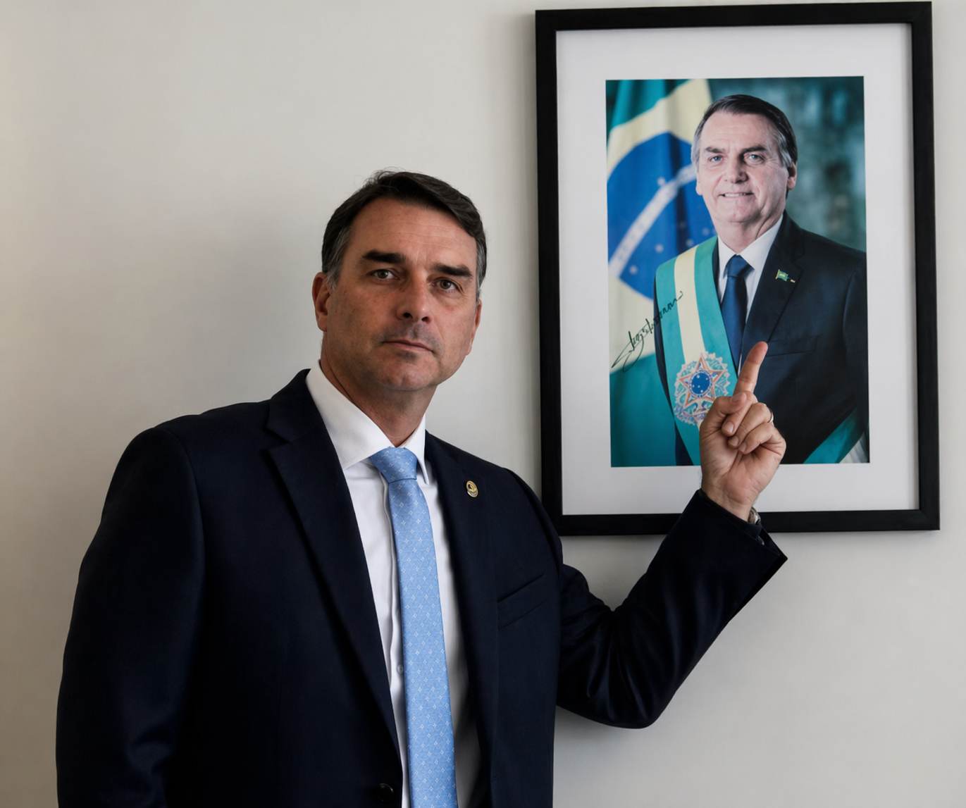 Flávio Bolsonaro apontando para uma foto de seu pai, Jair Bolsonaro.