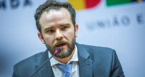 ministro da Fazenda, Dario Durigan, falando em microfone, sério, sem olhar para a câmera