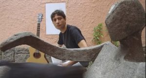 O compositor brasileiro Alvin L sério, olhando para a câmera, de camiseta preta