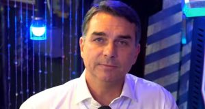 O senador Flávio Bolsonaro (PL) sério, de camisa social branca