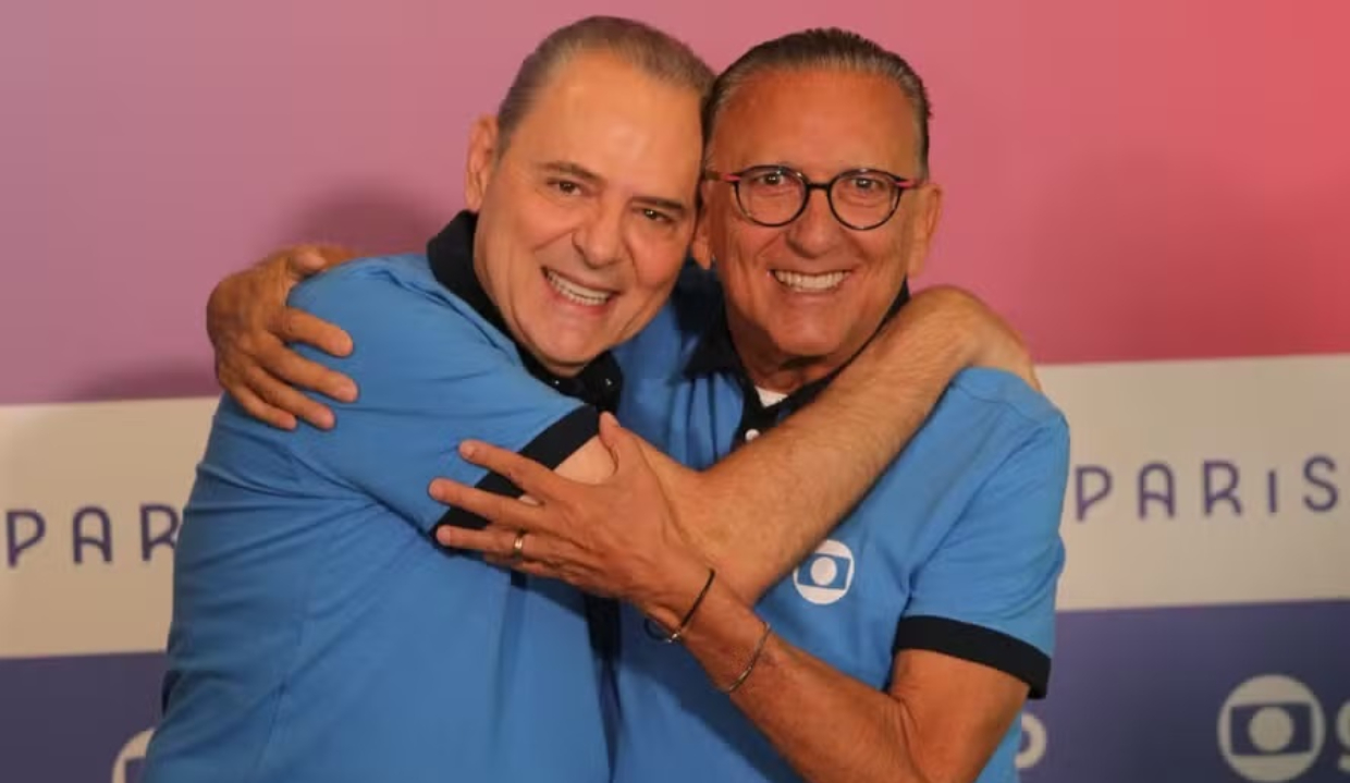 Luis Roberto e Galvão Bueno abraçados, sorrindo para a câmera