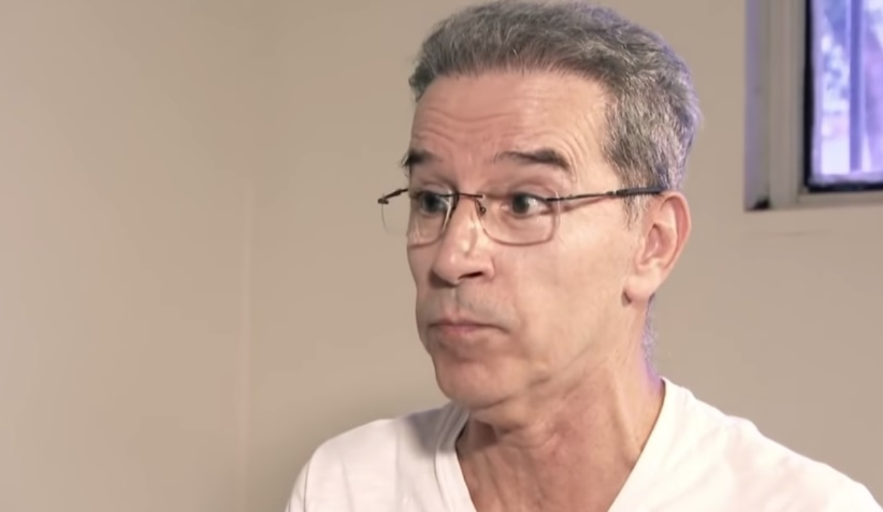 ex-senador Luiz Estevão de óculos de grau e camiseta branca, com expressão de espanto, sem olhar para a câmera
