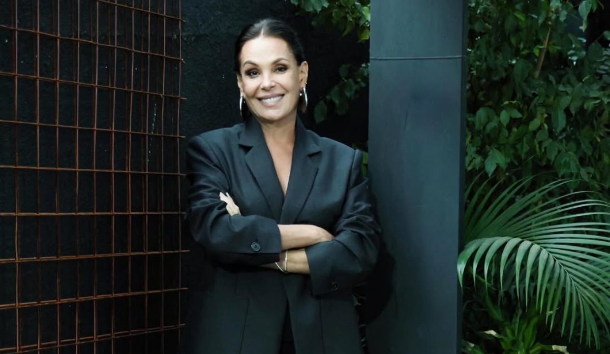 Carolina Ferraz de roupa preta, em pé, sorrindo, de cabelo preso