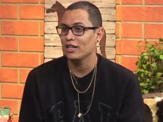 O dono da página “Choquei”, Raphael Sousa Oliveira, de moletom preto e óculos de grau, falando e olhando pro lado, sério