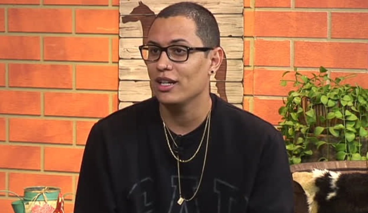 O dono da página “Choquei”, Raphael Sousa Oliveira, de moletom preto e óculos de grau, falando e olhando pro lado, sério