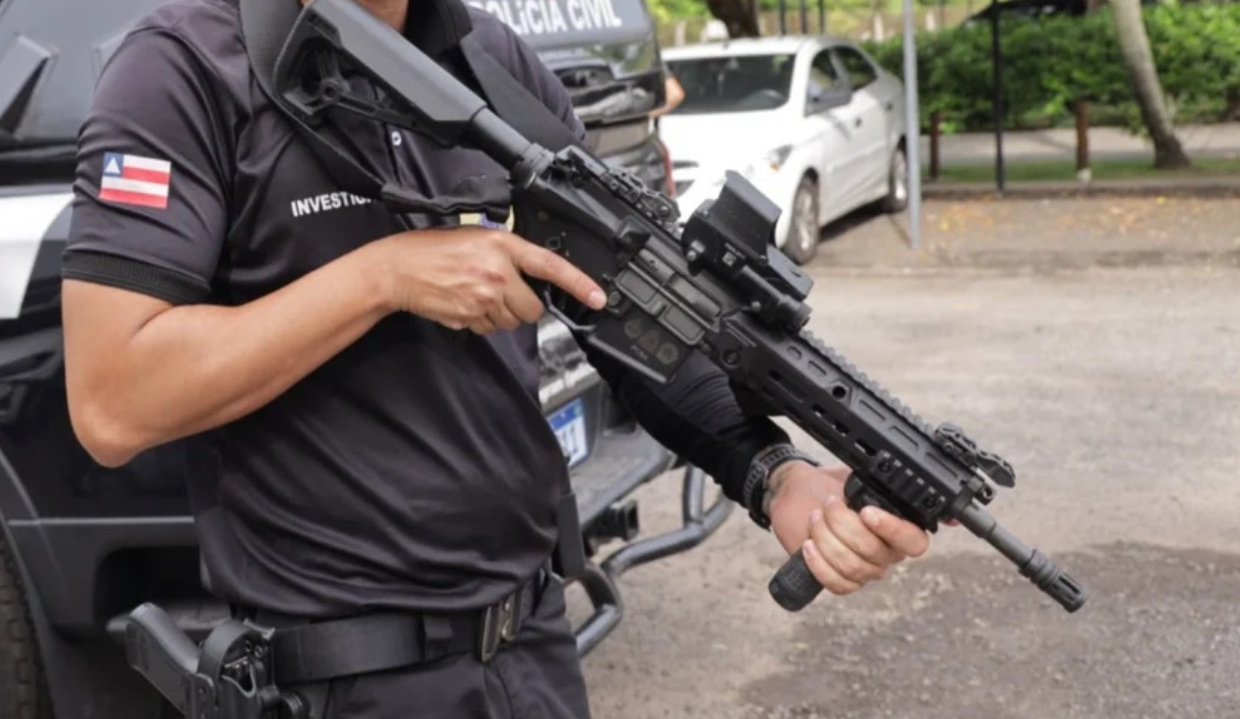 Agente da Polícia Civil da Bahia com armas, sem mostrar o rosto