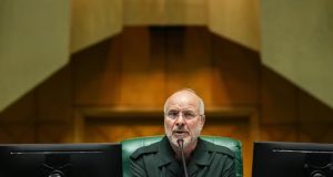 O presidente do Parlamento do Irã, Mohammad Bagher Ghalibaf, sério, sentado, falando em microfone