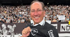 John Textor sorrindo, com óculos de grau e camisa do Botafogo