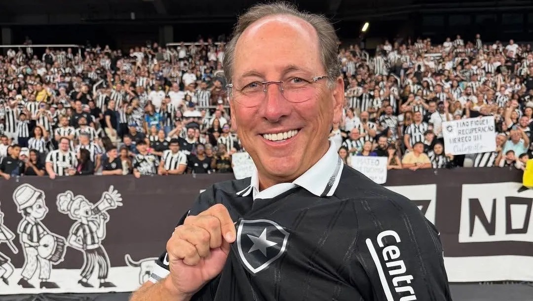 John Textor sorrindo, com óculos de grau e camisa do Botafogo