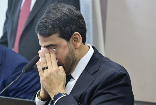 Jorge Messias, da AGU, de cabeça baixa, com as mãos no rosto