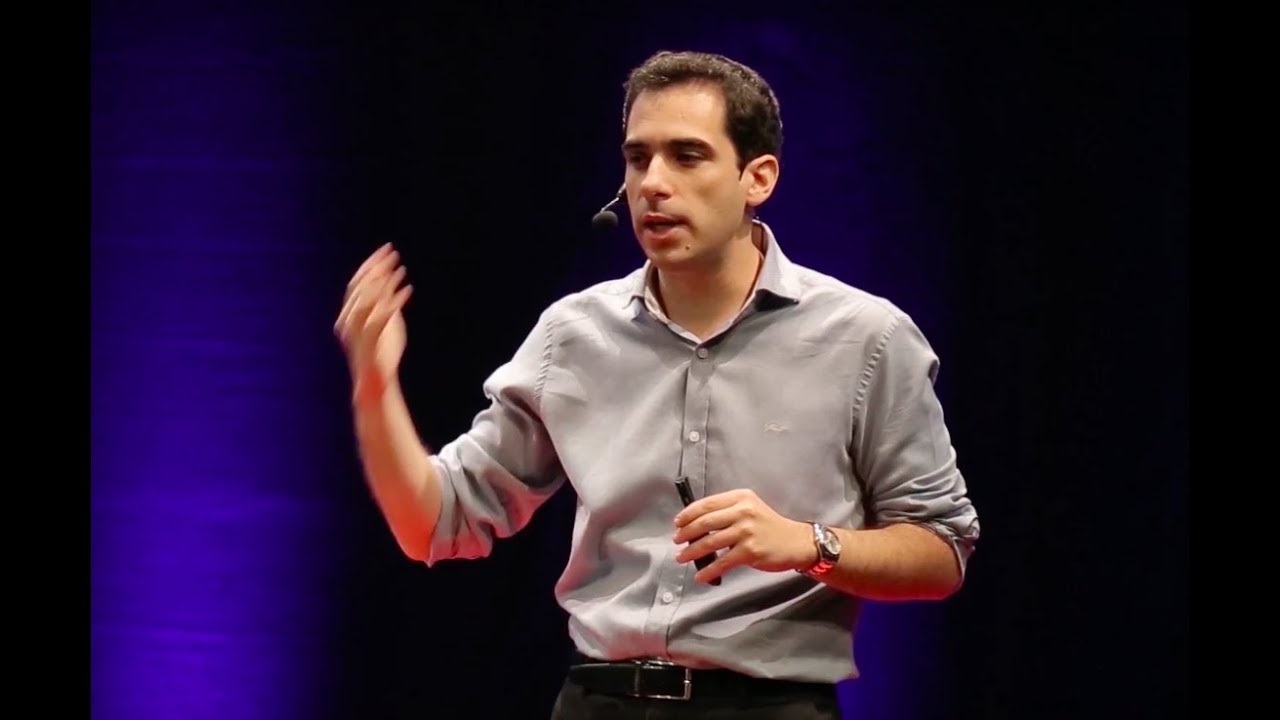 O economista e comentarista Richard Rytenband falando e gesticulando, em pé, de roupa social