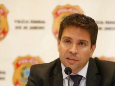 ex-deputado federal Alexandre Ramagem sério, falando, com painel da PF ao fundo