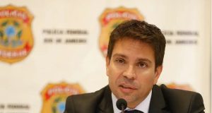 ex-deputado federal Alexandre Ramagem sério, falando, com painel da PF ao fundo