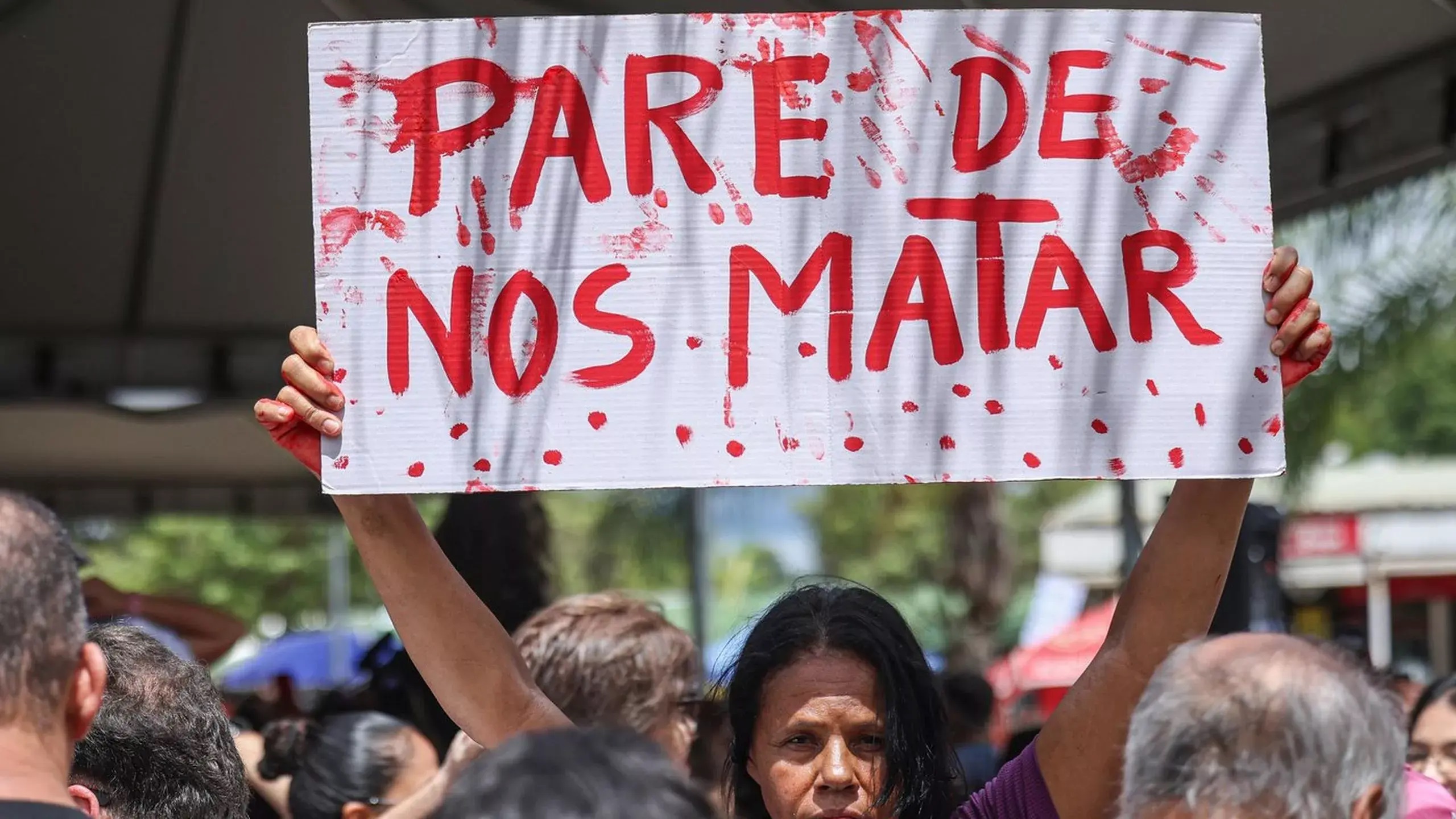 Manifestante com cartaz em protesto contra o feminicídio