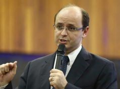 O secretário de Estado de Educação de Minas Gerais, Rossieli Soares, falando e gesticulando, de óculos de grau