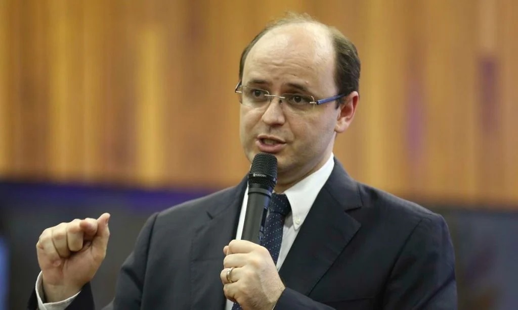 O secretário de Estado de Educação de Minas Gerais, Rossieli Soares, falando e gesticulando, de óculos de grau