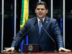 presidente do Senado, Davi Alcolumbre, em pé, falando, sério