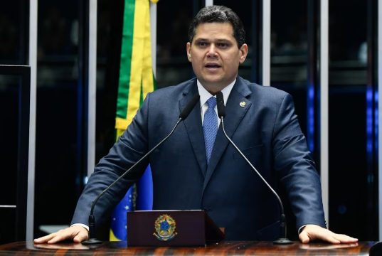 presidente do Senado, Davi Alcolumbre, em pé, falando, sério