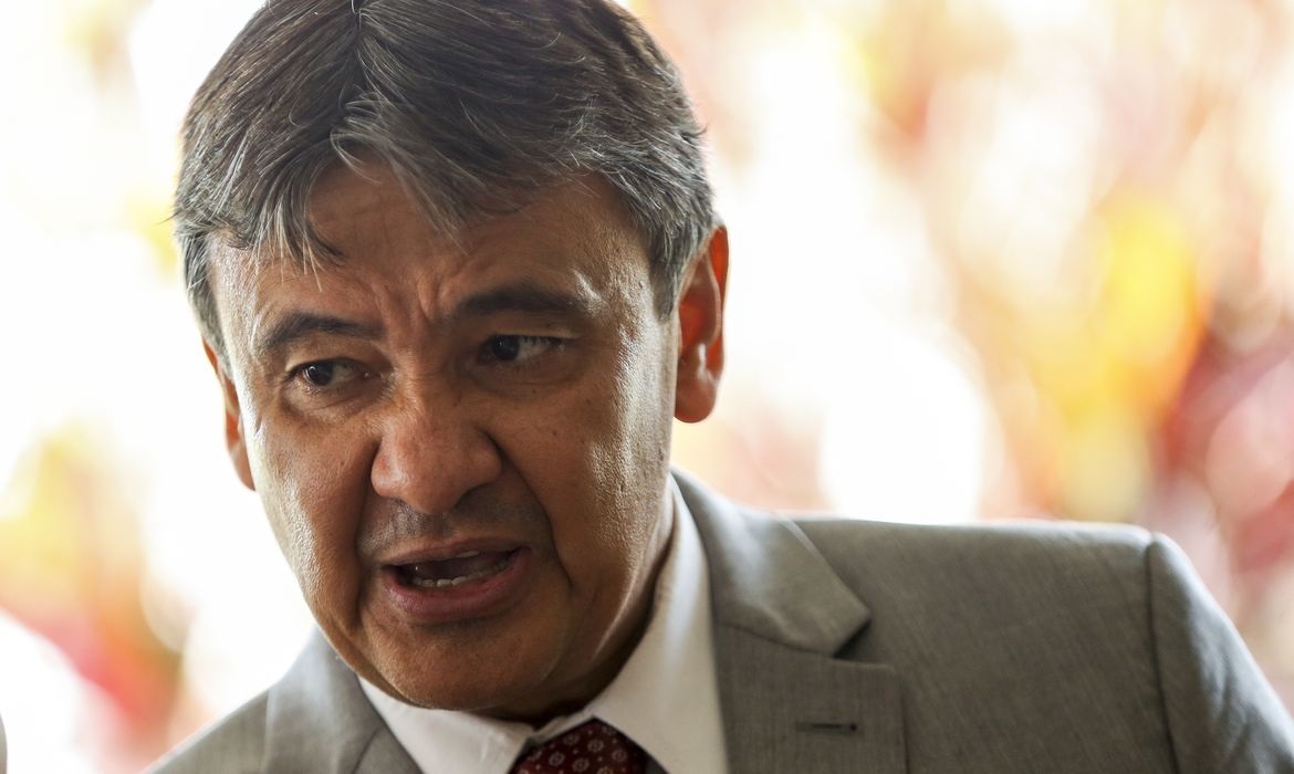 O ministro do Desenvolvimento Social, Wellington Dias, falando e olhando pra baixo, sério, de roupa social cinza