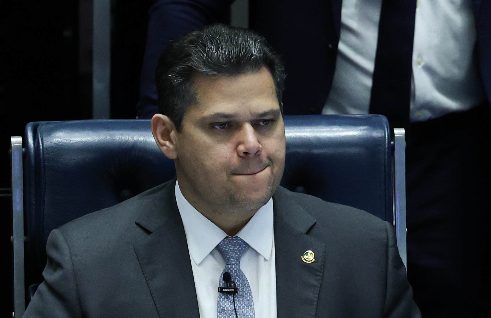 presidente do Senado Federal, Davi Alcolumbre (União-AP), fazendo careta, sem olhar para a câmera, sentado