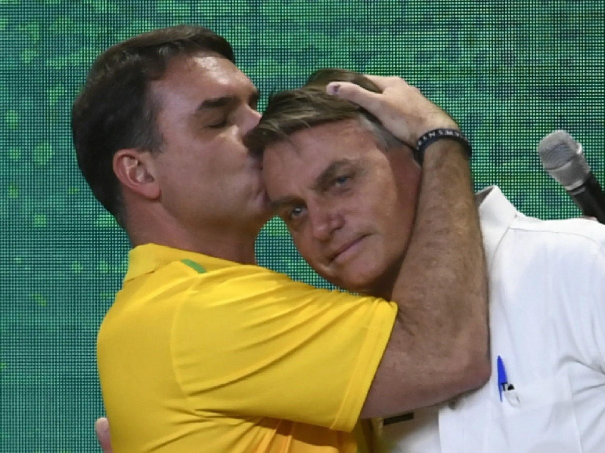 O senador Flávio Bolsonaro (PL-RJ) abraçando e beijando a cabeça de Jair Bolsonaro