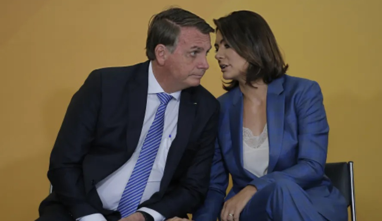 Jair e Michelle Bolsonaro sérios, conversando, sentados lado a lado