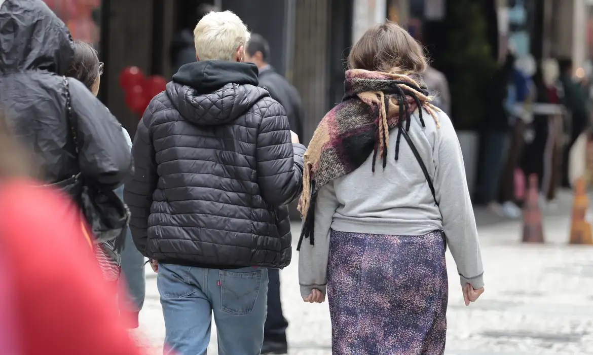 Pessoas agasalhadas, andando, de costas