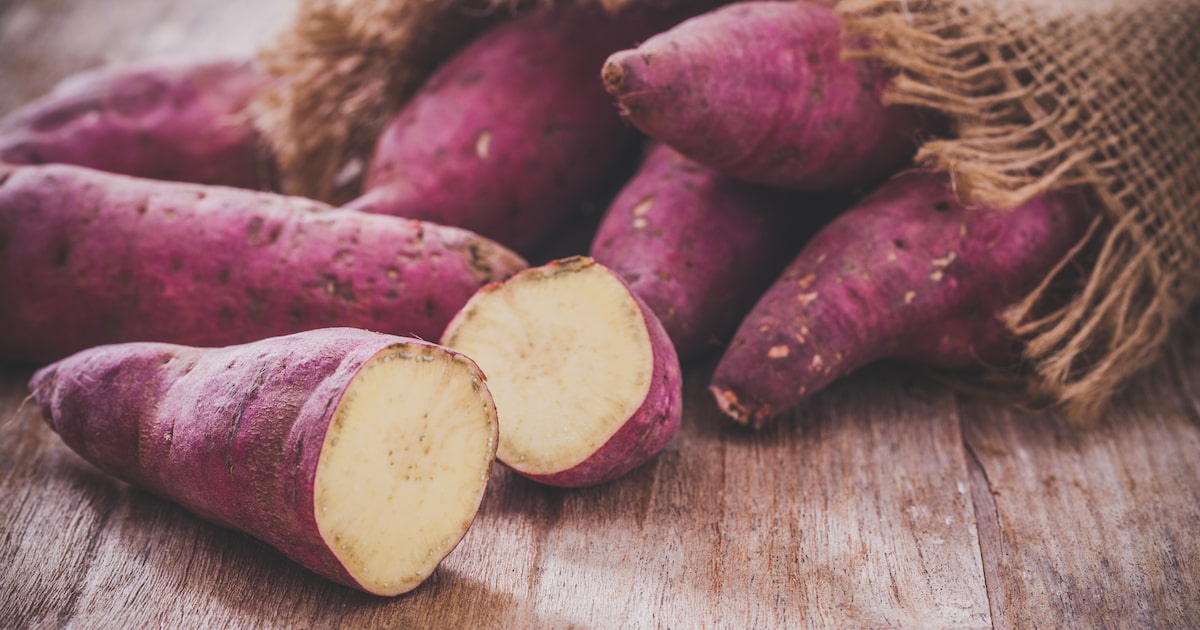 Batatas-doces cruas sobre superfície de madeira