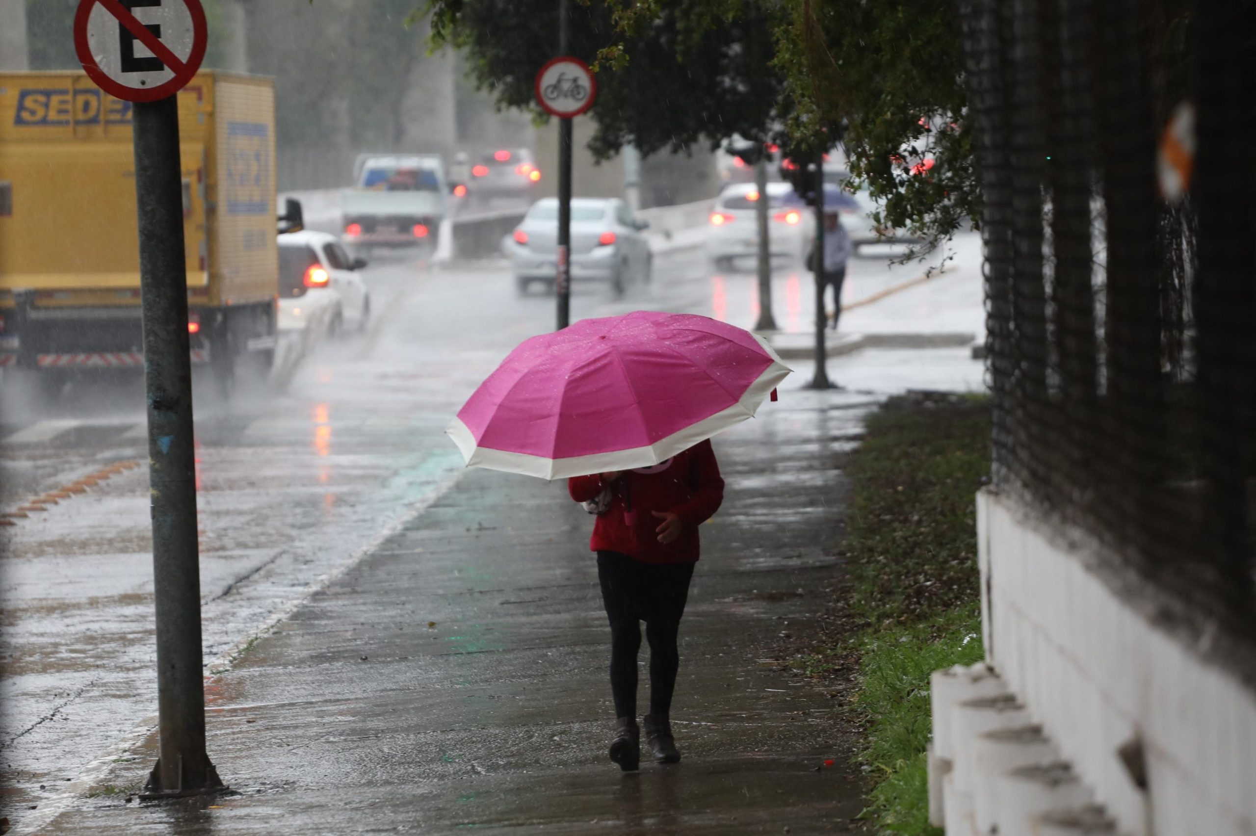 Pedestres caminham sob chuva e frio em São Paulo