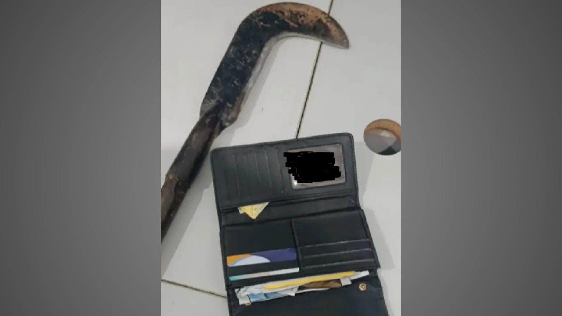 Foice com cabo de madeira e bolsa apreendidas pela polícia