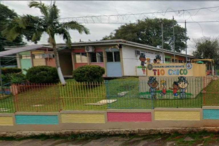 Fachada da Escola de Educação Tio Chico, com muro colorido e área gramada ao redor