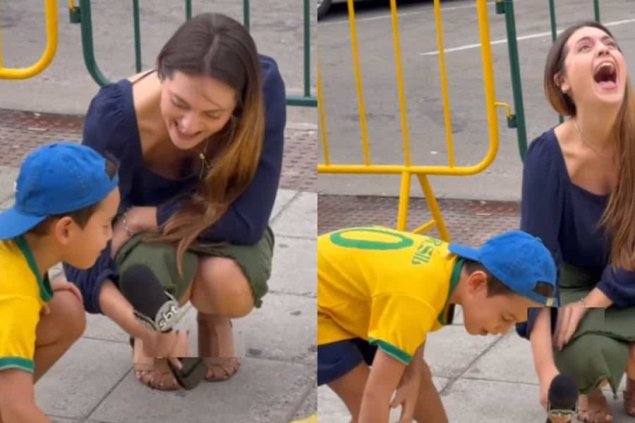 Menino entrevistado por repórter do SBT durante pintura de rua para a Copa do Mundo