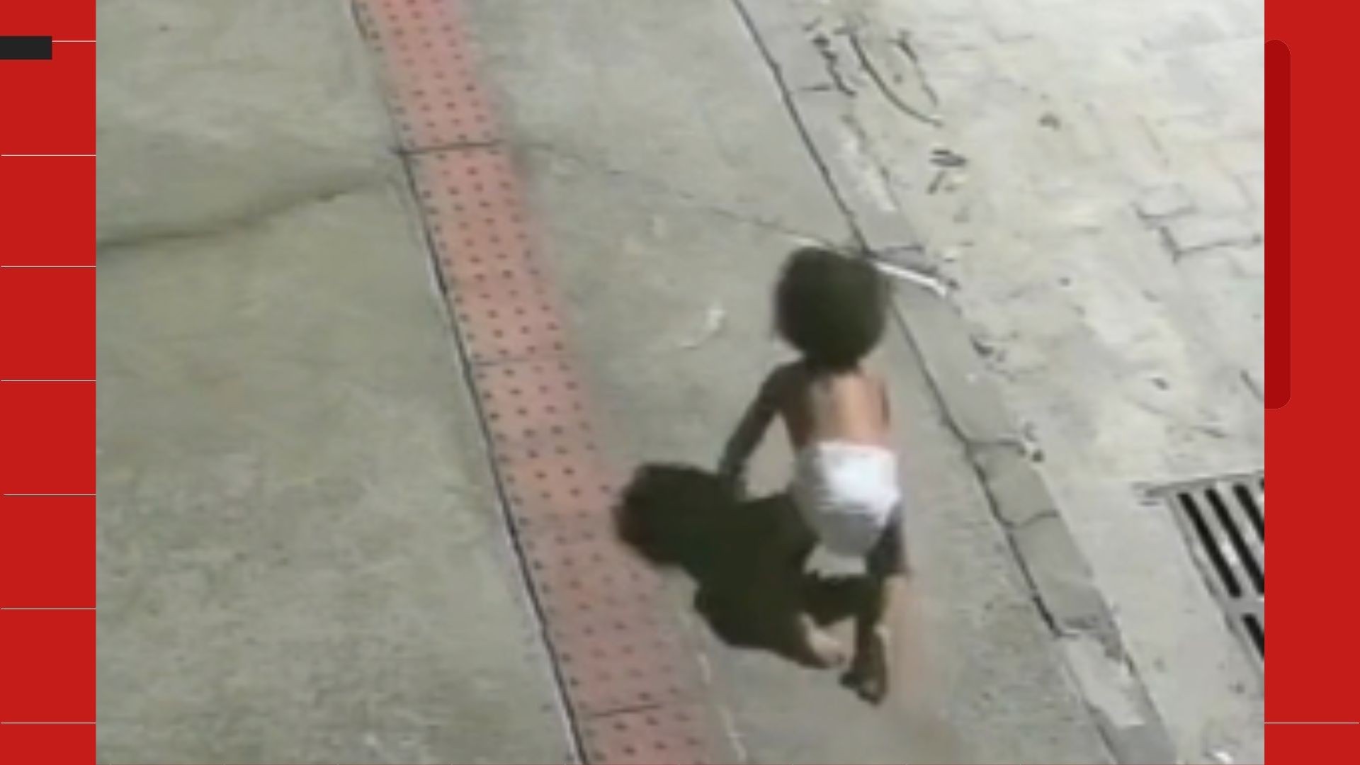 Bebê de fralda engatinhando em calçada durante a madrugada