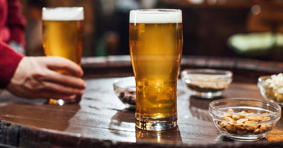 Pessoas com copos de bebida em ambiente de bar