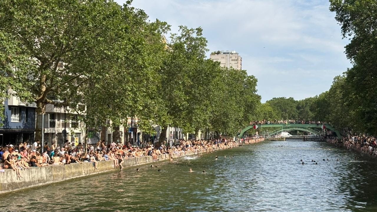 Pessoas reunidas no Canal Saint-Martin, em Paris, durante dia de calor