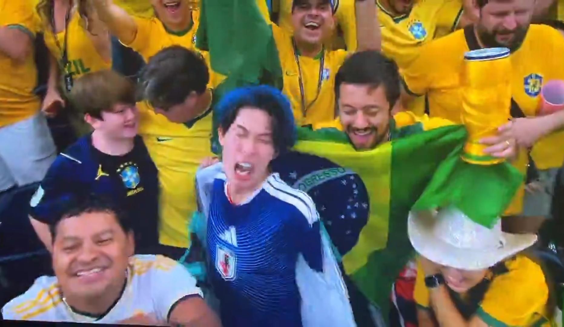Torcedor japonês de cabelo azul com camisa da seleção japonesa na arquibancada