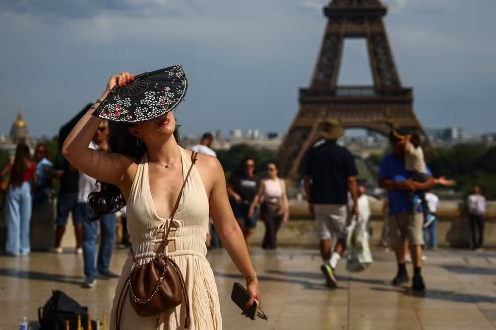 Mulher com um leque perto da Torre Eiffel - REUTERS/Sarah Meyssonnier