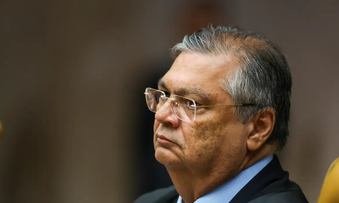 O ministro Flávio Dino de perfil, sério, em close