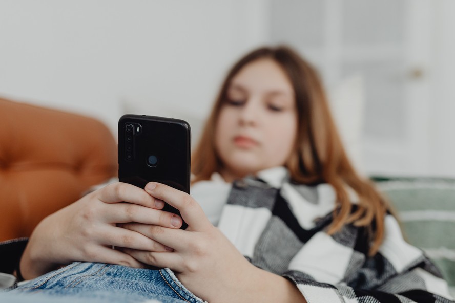 Adolescente usando celular