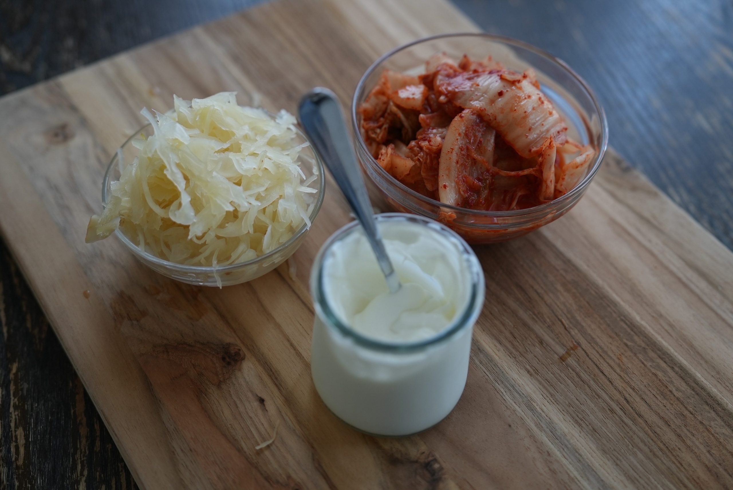 Kimchi, chucrute e iogurte sobre uma mesa