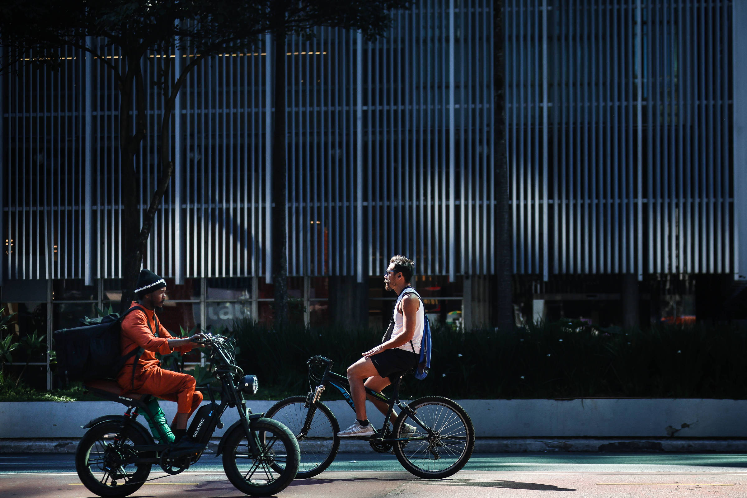 Ciclistas em bicicleta elétrica e convencional na ciclovia da avenida Paulista, em São Paulo