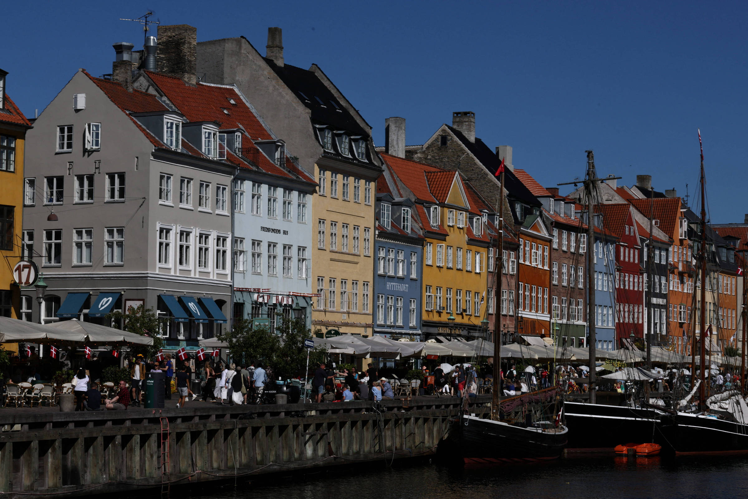 Canal de Nyhavn, em Copenhague, com fachadas coloridas e barcos em dia ensolarado